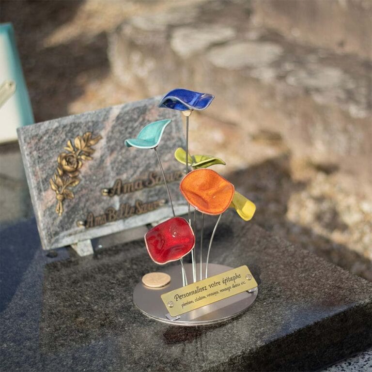 Ensemble d'une plaque funéraire personnalisée en inox et d'une composition de fleurs en céramique, créant un hommage cohérent