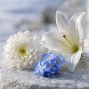 Lys blanc, chrysanthème blanc et myosotis bleus symbolisant le souvenir, la pureté et l’hommage respectueux